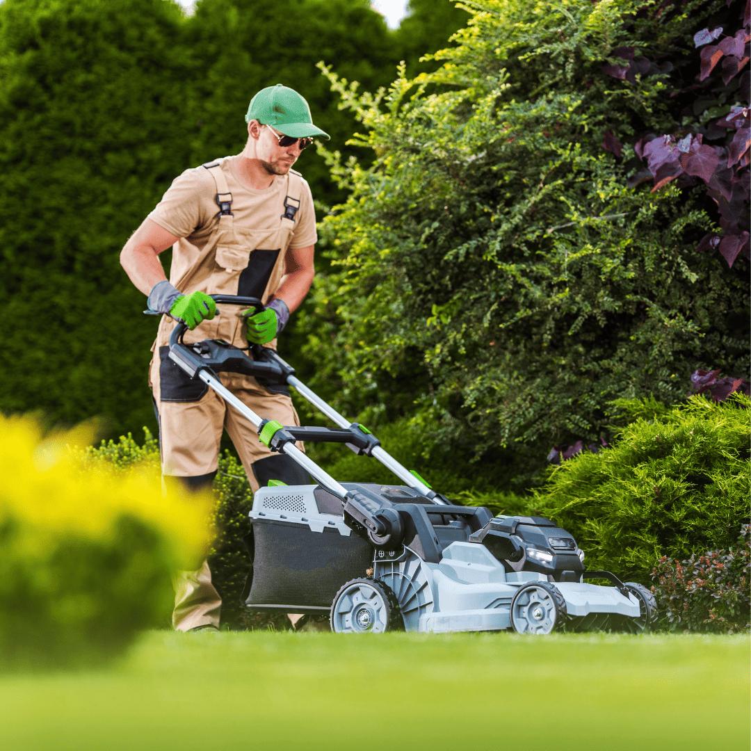 Muž seká trávník zahradní sekačkou